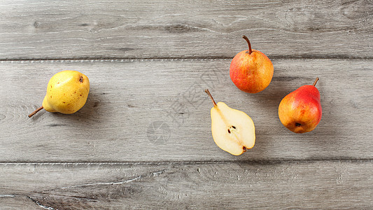 桌顶风景 成熟的梨子 一个切成两半 在灰色木质桌上图片