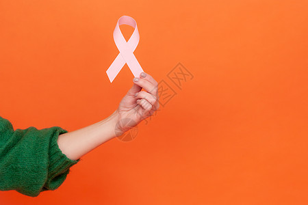 在橙色背景下 画出有情感的年轻卷发女人的肖像肿瘤学毛衣女性治愈手术癌症医生外科手臂预防图片