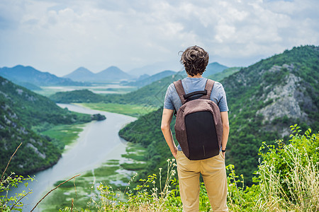 在 Skadar 湖海岸附近的河背景峡谷中的男子游客 黑山最著名的景色之一 河流在山间拐弯倒流天空公园朋友们旅游蓝色天线全景曲线图片