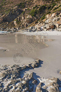 开普敦海滩的岩石海岸线 背景是山脉和复制空间 与岩石在海洋岸边的视图 寒冷的日子里 山海的岩石海岸冲刷着沙滩图片