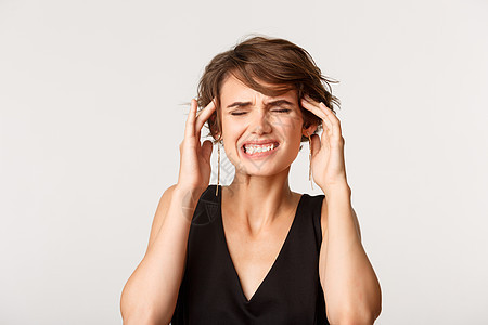 女性触碰头部和严酷 头头痛或偏头痛 站在白背景上站立的近身妇女图片