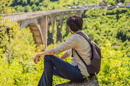 黑山 塔拉河桥背景中的男游客 周游黑山的概念 黑山的景点石头公园塔拉森林旅游峡谷观光秀场全景男人背景图片