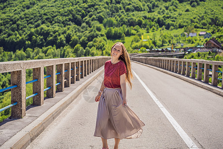 背景于特拉河沿岸的桥的妇女游客 在黑山周围旅行的概念国家森林建筑学天空公园女士风景纪念碑观光吸引力图片