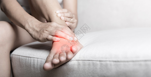 坐在沙发上的亚裔妇女在家里脚部感到疼痛 脚踝受伤伤害解剖学女性韧带肌腱病人药品身体脚跟扭伤图片
