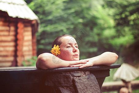 妇女户外享受热浴缸里的温泉女性女士增值税游客水池热带旅游热水澡游泳护理图片