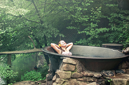 妇女户外享受热浴缸里的温泉热水澡黑发治疗护理假期热带闲暇女性旅游女士图片