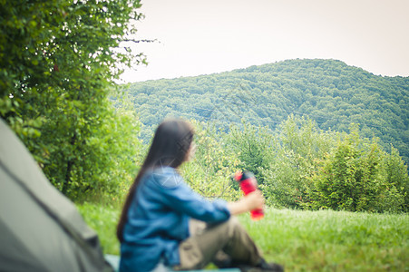 妇女在帐篷附近的山上 是可喜的幸福远足者冒险爬坡女性旅行旅游女士女孩运动图片