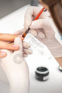用透明抛光剂覆盖指甲的修美术师化妆品女孩程序搪瓷治疗服务沉积手指刷子工具图片