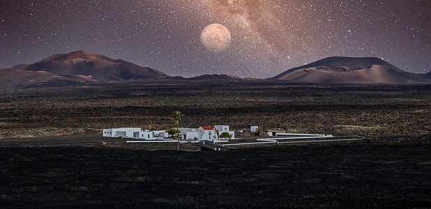 Timanfaya 国家公园火山口惊人的夜间全景景观 西班牙加那利群岛兰萨罗特岛 La Gueria 上空的满月 艺术夜空图片图片