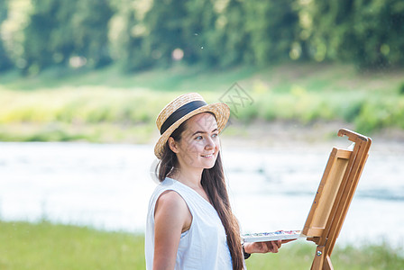 户外美丽的女孩艺术家调色板头发闲暇天赋女性微笑画笔画架水彩帆布图片