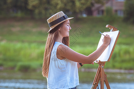 户外美丽的女孩艺术家空气画架画家绘画闲暇毯子褶皱画笔天赋工艺图片