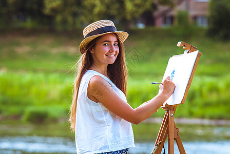 户外美丽的女孩艺术家女性画架绘画头发空气帆布调色板女士画家爱好图片