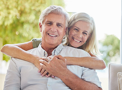 一对快乐的成熟白人夫妇在家里一起放松时拥抱和表达爱意 退休夫妇坐在一起时亲密无间男人成年人女士女性丈夫夫妻房间男性沙发房子图片