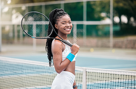 非洲裔美国女人在球场上拿着她的网球拍 年轻的女孩准备在外面打网球 微笑的女人站在她的网球俱乐部外面准备比赛图片