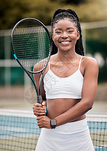 准备好网球比赛的年轻女孩 非洲裔美国女人在网球场上拿着她的球拍 一位美丽微笑的网球运动员站在她俱乐部的球场上的画像图片