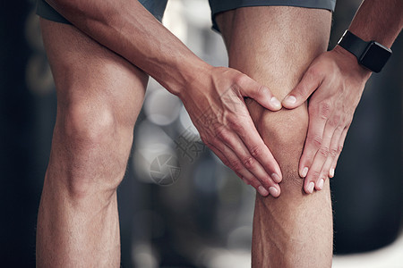 一名混血男子在健身房锻炼时抱着酸痛的膝盖的特写镜头 在锻炼期间因关节骨折和肌肉发炎而腿部疼痛的人 与僵硬的身体痉挛作斗争 导致不图片
