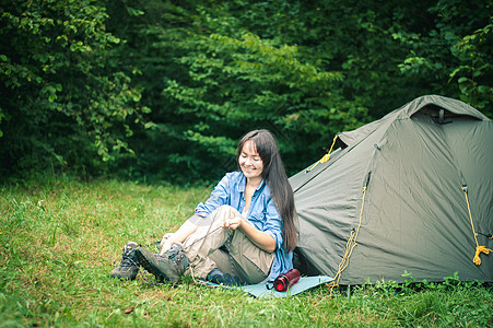 妇女在帐篷附近的山上 是可喜的女士远足者娱乐幸福岩石远足森林享受成人女孩图片