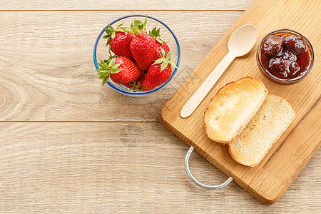 碗里传统自制草莓果酱 新鲜的浆果 还有木质土司健康食物桌子木板红色绿色早餐季节饮食甜点图片