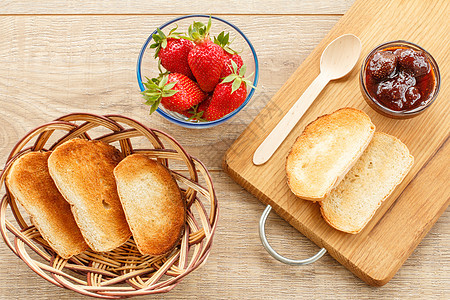 碗里传统自制草莓果酱 新鲜的浆果 还有木质土司绿色红色早餐桌子食物季节饮食水果甜点健康图片