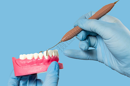牙科医生手与人下巴和牙科仪器的布局牙齿治疗药品工具医疗诊所蓝色卫生探险家外科图片