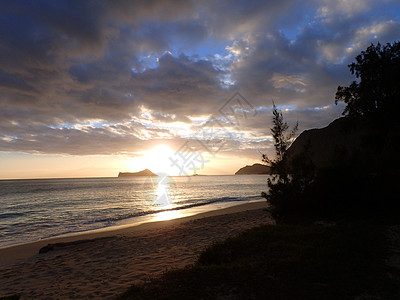 早起在罗岩岛的韦马纳洛海滩 破云而出日落辉光椰子反射海洋海岸热带岩石日出旅行图片