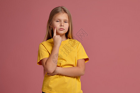 穿着黄色T恤的小女孩 想一想地露出手指图片