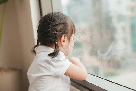 对可爱的小女孩反向看 看着窗外公寓思维女孩悲伤童年窗户孤独孩子下雨图片