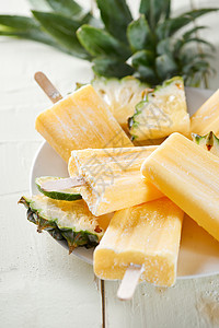 木制白色背景的聚集中菠萝椰子冰棒派对甜点水果黄色热带棒冰果汁奶油图片