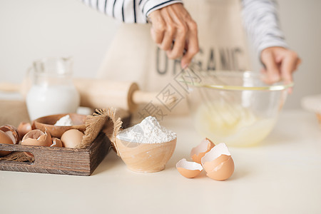年轻男子的手用鸡蛋和糖来烤水果蛋糕 男性在白桌边做馅饼烘烤面粉面包木头饼干食物黄油面团糕点厨房图片