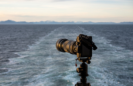 三脚架上的专业摄像头回望游轮后海洋海岸全景假期风景旅行日落旅游唤醒海岸线图片