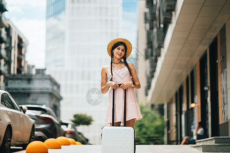 携带手提箱和照相机的年轻女子肖像白色手提包游客黑发旅游成人旅行城市女性女士图片