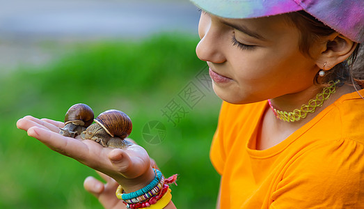 孩子看着蜗牛 有选择的专注横幅镜片青年学校童年女孩花园冒险生物学植物学图片