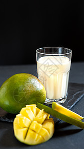 牛奶燕麦在黑色背景上加芒果的牛奶饮料 经典的芒果奶昔Lassi 印度传统的热饮奶制品酸奶水果恋人玻璃美食果汁甜点热带薄荷背景