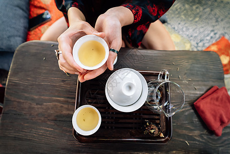 顶端观茶为茶叶仪式背景设置了木制桌传统陶瓷黑色饮料绿色女士服务蓝色棕色制品图片