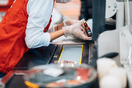 一个女人在超市的报到机上读条码扫描售货员扫描器技术店铺服务交易柜台出纳员顾客图片