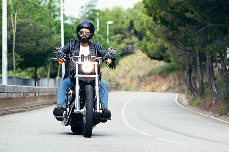 在路上驾驶摩托车的摩托车图片