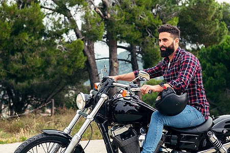 挂胡子的男子骑摩托车脱头盔图片