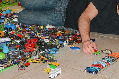 父亲在地板上玩儿子的玩具车图片