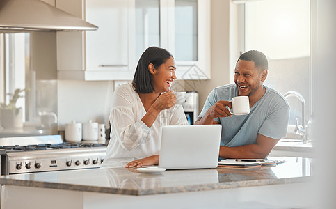 让我们来谈谈我们今天的计划 一对夫妇喝咖啡 同时在家里的厨房用笔记本电脑图片