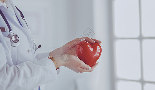 以轻度背景持有心脏心部听诊器的女医生女孩护士职业长袍工人援助成人卫生诊断心脏病学图片