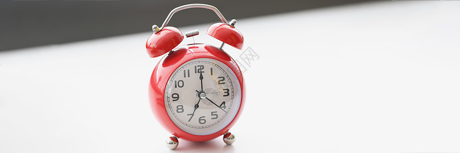 白色表面上的复古红钟显示早上七点 醒来 上班时间小时数字滴答运动戒指手表桌子小憩警报工作背景图片
