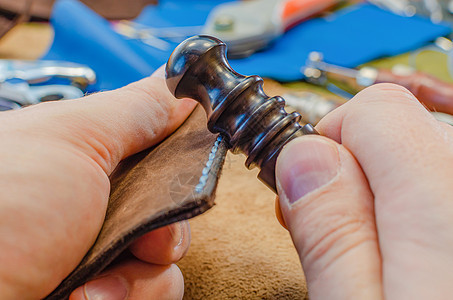 皮具制造过程 用于缝制包 钱包 手拿包的工具 彩色皮革件 特写作坊鞋类缝纫手工鞋匠劳动皮革加工男人工厂工作图片