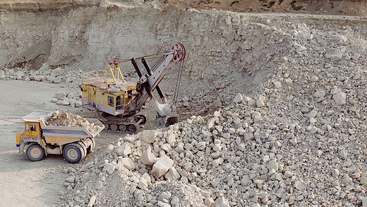 挖掘机将土壤装载到矿用自卸卡车中 在采石场提取铁矿石的设备 在采石场开采铁矿石的过程 铁矿石采石场的智能流程图片