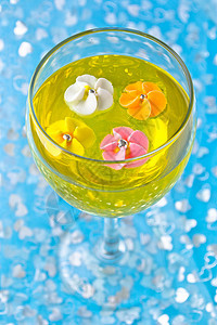 一杯含黄果冻的糖花粉色食物甜点蓝色背景高脚杯黄色图片