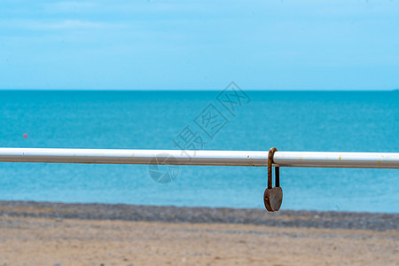 蓝海背景的鲁斯提爱情 模糊了旧的铁链日栅栏 从浪漫地平线上的钢铁概念金属锁 浪漫情人图片