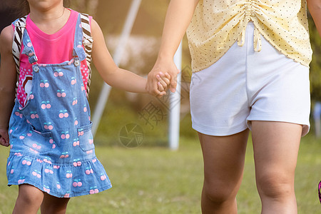 第一次背着书包上学的母子牵手 妈妈带领一个小女孩上一年级 小女孩很高兴并准备好学习 回到学校图片