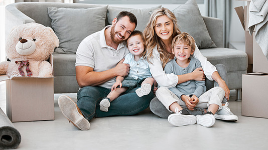 白人家庭微笑着放松 一起坐在新家休息室的地板上 父母搬进他们的房子后拥抱他们的孩子 兄弟姐妹与妈妈和爸爸结合图片