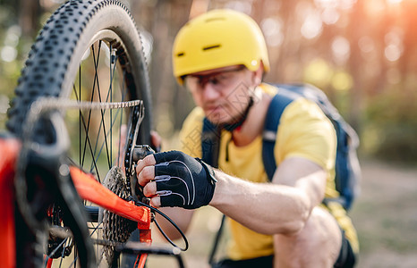 Cyclist检查链轮缺陷男人闲暇眼镜冒险森林环境晴天勘探小路娱乐图片