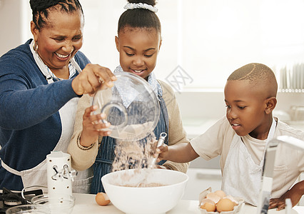 奶奶烤面包时 时间飞逝 一个祖母在家和两个孙子一起烘烤背景图片