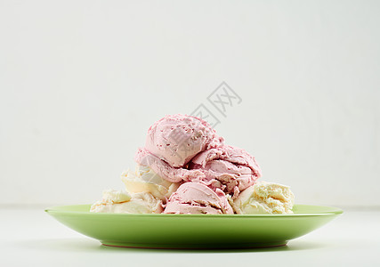 香草和草莓冰淇淋夹在圆绿色盘子上圆形食物粉色白色赞成甜点奶制品浆果覆盆子奶油图片